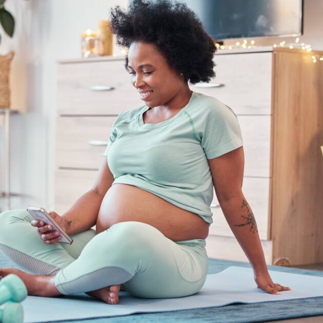 Yoga, pregnant and black woman with phone in home for social media and texting on workout break. Pr